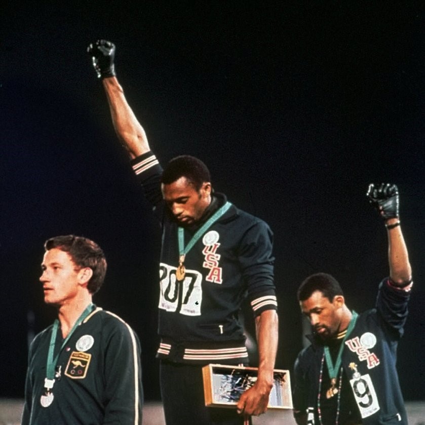 FILE- In this Oct. 16, 1968 file photo, U.S. athletes Tommie Smith, center, and John Carlos, right, stare extend their gloved hands skyward after Smith received the gold and Carlos the bronze for the 200 meter run at the Summer Olympic Games in Mexico City. Causes across the political spectrum have long used distinctive salutes to identify themselves. When Anders Behring Breivik, the far-right suspect in the massacre of 77 people in Norway, pulled his right hand to his chest and then thrust his arm out with a clenched fist after an Oslo courtroom guard removed his handcuffs on Monday, April 16, 2012; it was hardly the first time such a salute has been flashed (AP Photo/File)